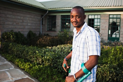 Photo: Person with a disability standing in front of building. 